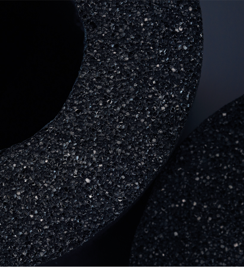 Vertical close-up of black elastomeric insulation material for K-FLEX web news content.