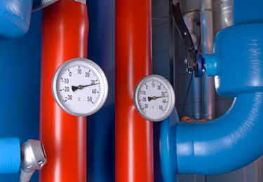 Red and blue insulated pipes with two analog temperature gauges.